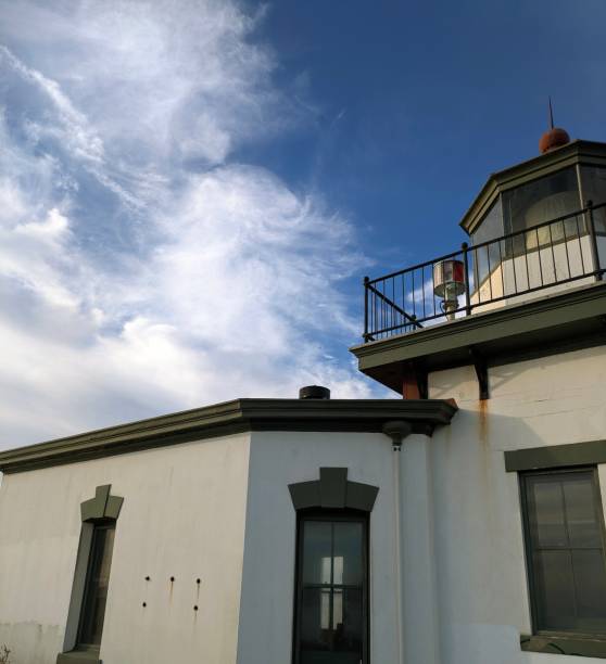 istock Antique Lighthouse Weathered Against Blue Sky with clouds 2205401328