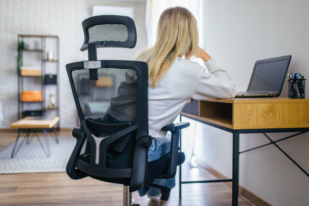 istock Young woman using phone while working on her laptop at home 2205401437