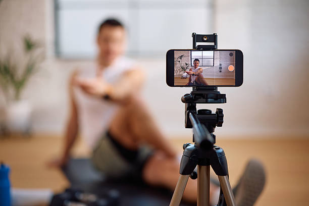 istock Close up of fitness instructor vlogging his workout guide. 2205402332