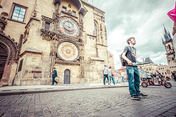 Prague, Czech Republic - June, 12, 2024:  A tourist guide is explaining the meaning of the Astronomical Clock in Prague.