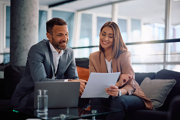 istock Happy colleagues cooperating while analyzing business reports in the office. 2205405412