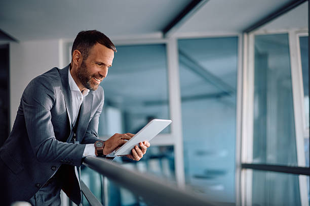 istock Happy businessman working on digital tablet in the office. 2205405450