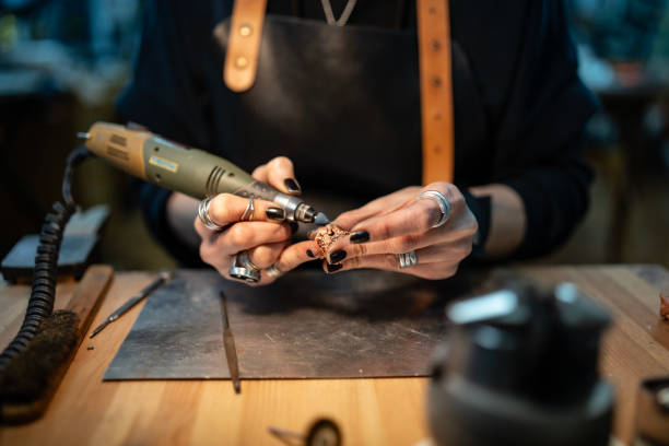 istock Craftswoman Using Rotary Tool for Detailed Jewelry Piece in Workshop 2205407369
