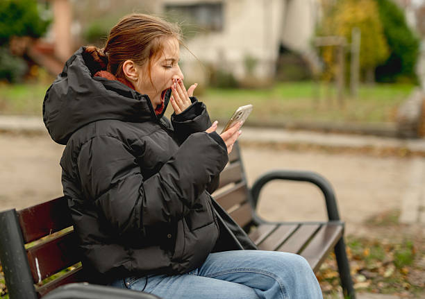 istock Girl Yawning While Sitting With Smartphone 2205412860