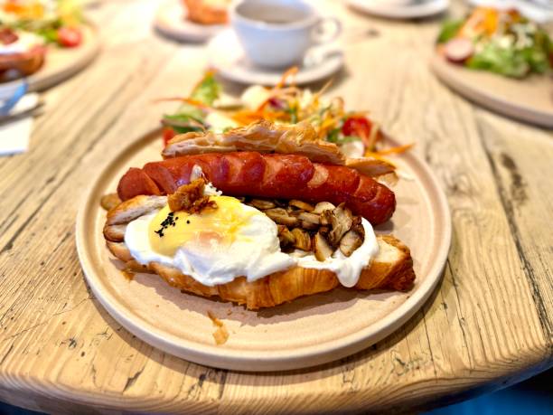 istock Croissant sandwich with sausage and poached egg served at breakfast 2205415842