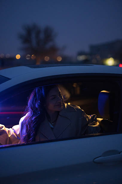 istock Sexy lady posing in a car in blue light 2205416636
