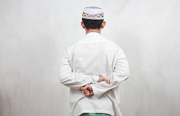istock Muslim Asian man facing backwards requires resting position in place holding hands behind his back 2205417190