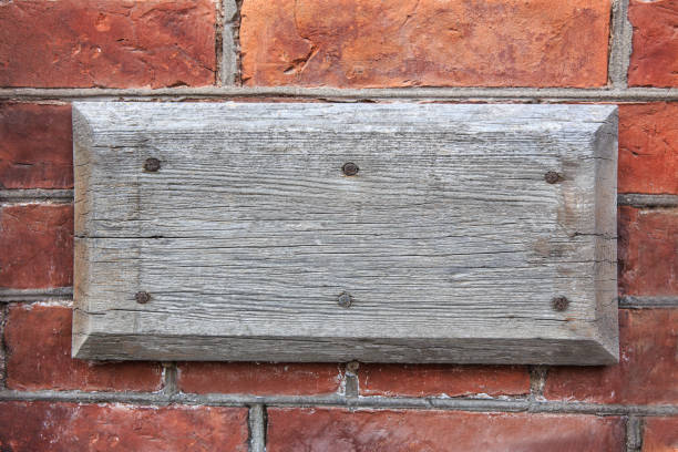 istock Old wooden blank sign on brick wall 2205425641