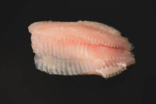 istock Fresh tilapia fillet on black background, top view. 2205428170