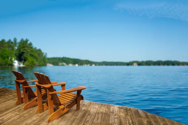 istock Adirondack chairs on a Muskoka dock with a softly blurred lake view. 2205429392