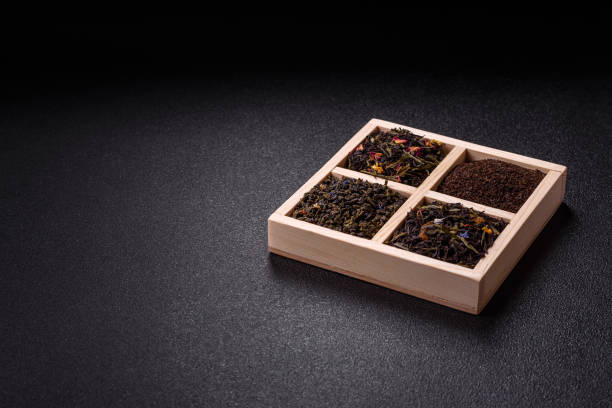 Different kind of Dry tea green, black, mint, rose and chamomile, wooden spoon in the box