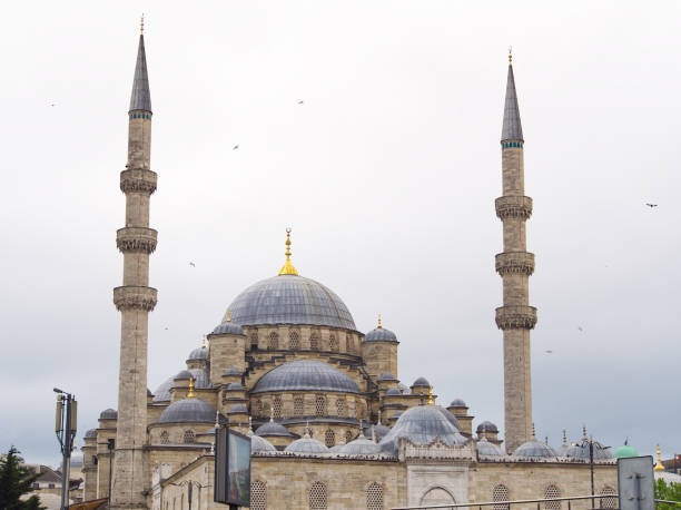 Majestic Ottoman-style mosque with a large central dome and two tall minarets against a cloudy sky