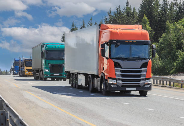 istock Large trucks move along a country road along the forest 2205431644