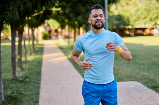 istock Young man jogging in a park during a sunny day 2205433562