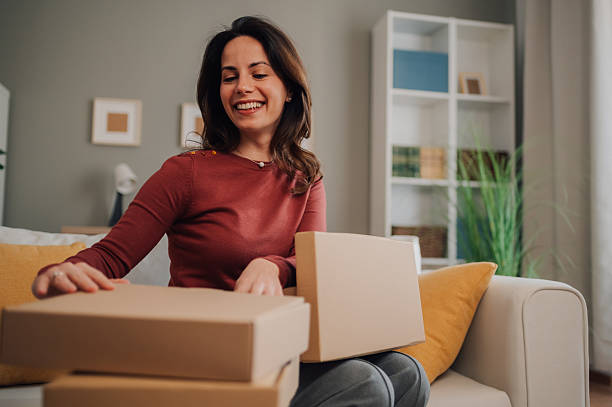 istock Woman opening received packages at home 2205435846