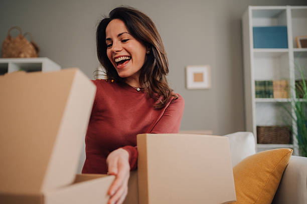 istock Happy woman unpacking cardboard boxes at home 2205435848