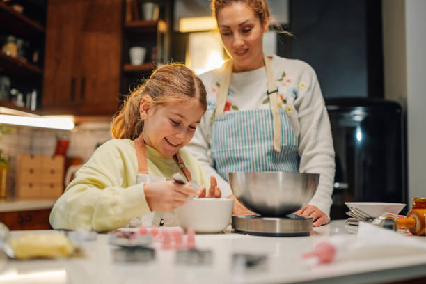 istock Mother and daughter baking together in modern kitchen 2205435944
