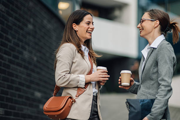 istock Two businesswomen talking and smiling during coffee break outside office 2205436537
