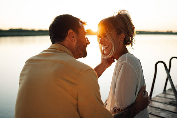 istock Romantic couple enjoying sunset on a wooden pier 2205437686