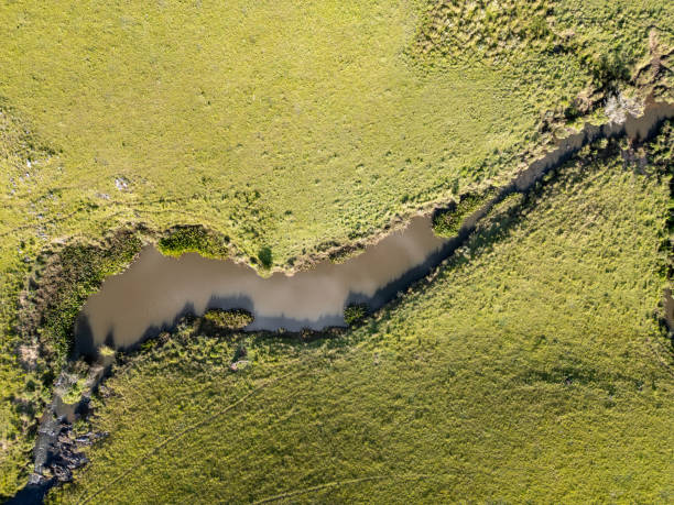 istock River in a farm field 2205437822