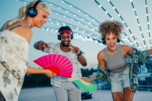 istock Friends listening music and dancing at silent disco event 2205437996