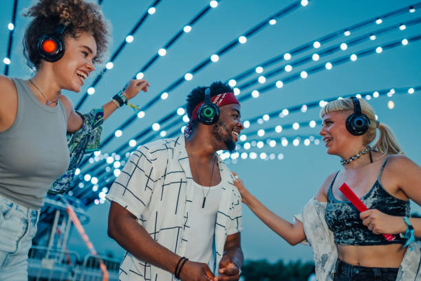 istock Friends enjoying music at silent disco festival under string lights 2205437998