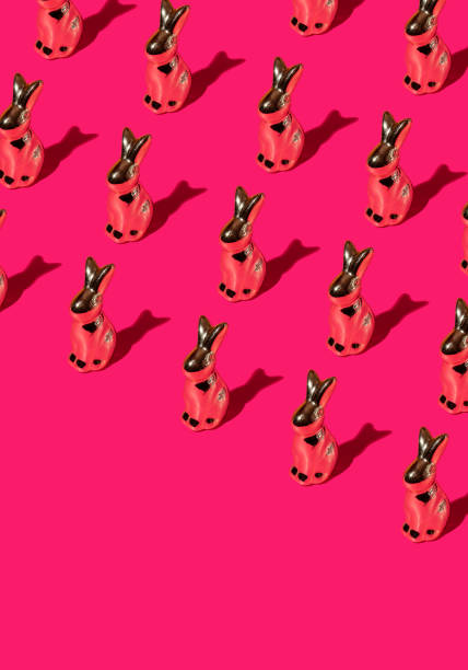 istock Pattern composition of Easter bunnies on hot pink background. Minimalist isometric concept. 2205439616