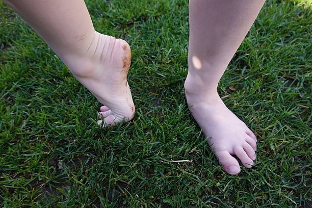 istock Barefoot child walking on grass experiencing nature 2205439981