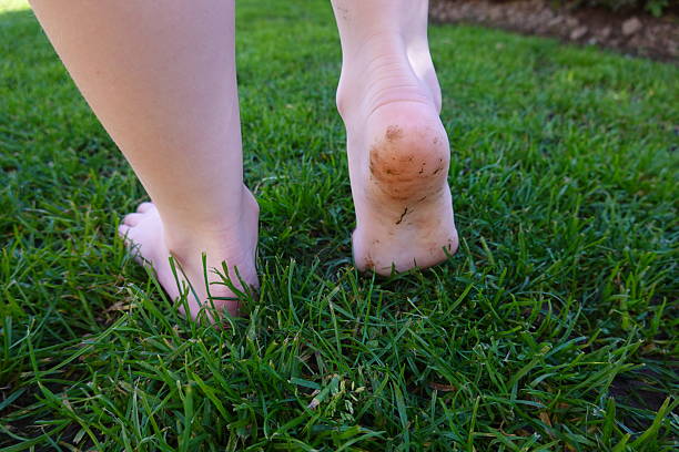 Barefoot child joyfully walking on lush grass, embracing the beauty of nature in a vibrant garden, feeling carefree and happy