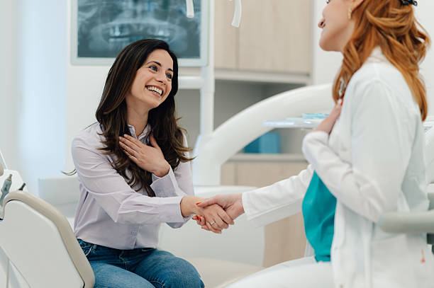 istock Happy patient shaking dentist's hand after successful dental checkup 2205440943