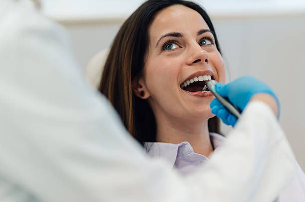 istock Dentist using intraoral scanner on patient's teeth during checkup 2205440947