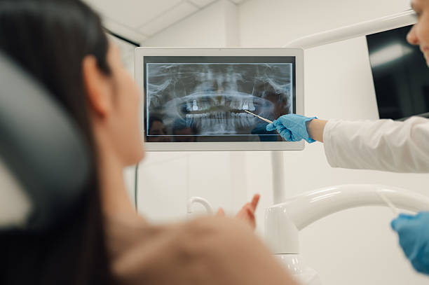 istock Dentist showing teeth x-ray to patient in modern clinic 2205440954