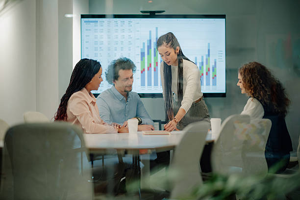 istock Diverse business team analyzing charts on a digital screen during a meeting 2205441271