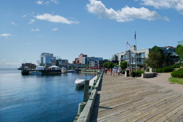 The Halifax waterfront comes to life on a bright summer morning, with boardwalk views stretching along the bustling harbour.