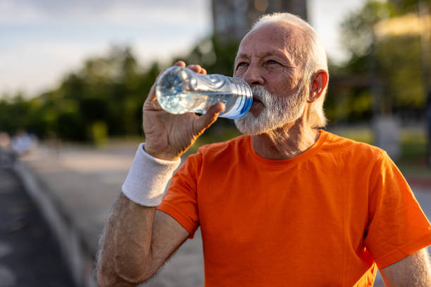 istock Senior man drinking water after exercising outdoors 2205442802