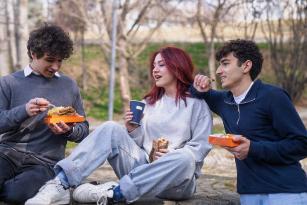 istock Friends taking a break outdoors eating 2205446275