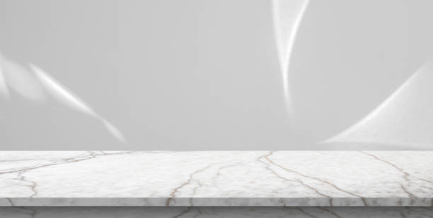 istock Marble table top with abstract shadow drop on white wall background for mockup product display 2205453691
