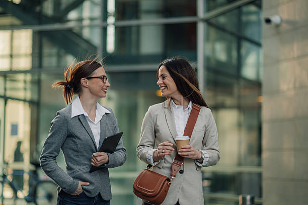 istock Two businesswomen walking and talking outside office building 2205454362