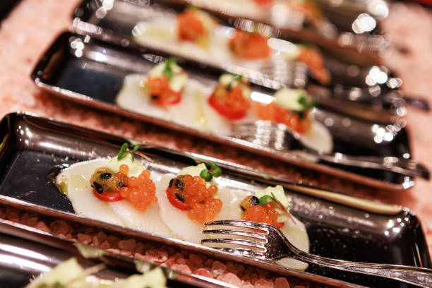 istock Elegant seafood appetizer featuring thinly sliced scallops, garnished with vibrant salmon roe 2205455130