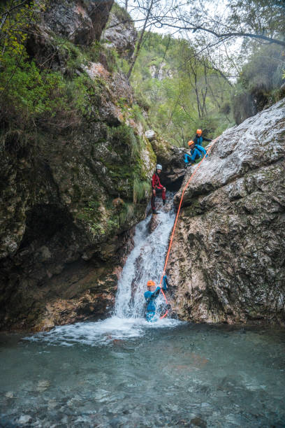 istock Canyoning Guide Leads Diverse Friends in Slide 2205456457
