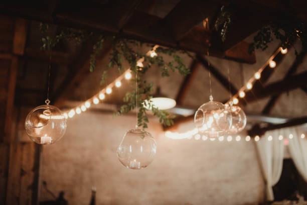 istock Hanging clear glass globes with candles and string lights 2205456774