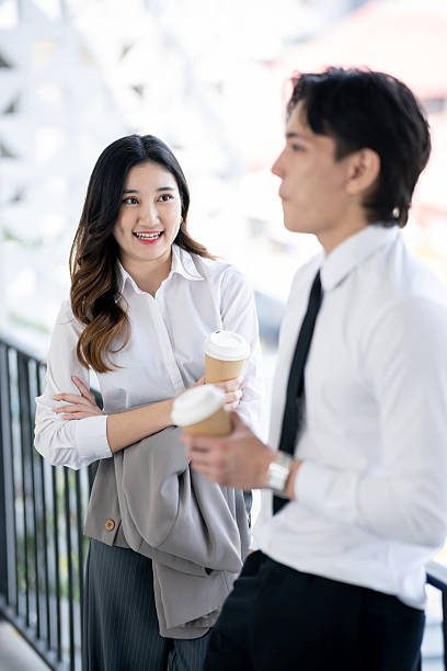 istock A businessman and a woman are talking about work and drinking coffee during the conversation. 2205459070