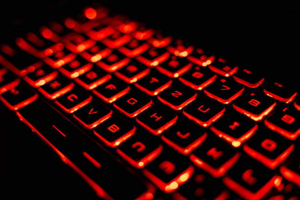 istock Glowing Red Backlit Gaming Laptop Keyboard Close-Up 2205459574