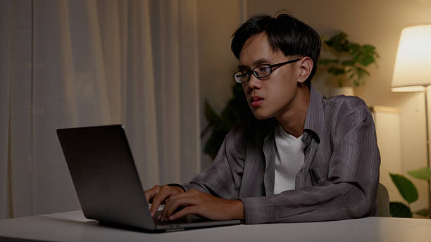 istock Asian man sits working on computer until late at night, tired and sleepy from working all day. Burnout, over time freelance, business , working at home. 4k. 2205460352