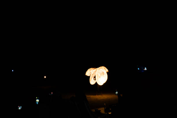 istock Fire dancers Swing fire dancing show fire show on the beach dance man juggling with fire 2205462210