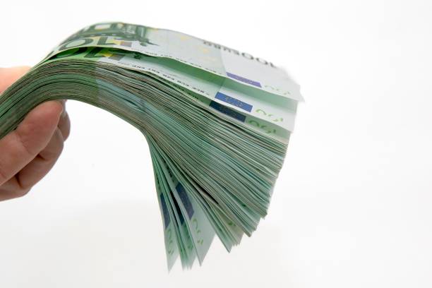 istock Thick stack of hundred euro banknotes held in hand, financial wealth concept 2205471663