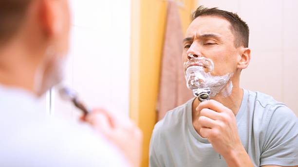 istock Man shaving his beard with a razor 2205472489