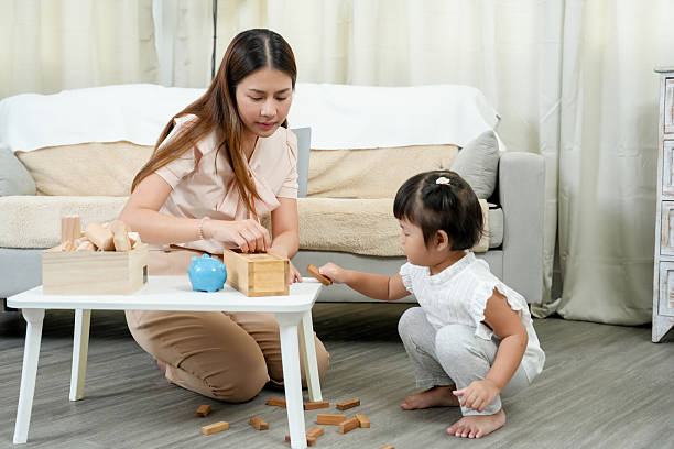 istock Asian female preschool tutor engaging young child in hands-on learning activities using wooden blocks enhancing fine motor skills early education cognitive development home-based teaching nurturing 2205473022