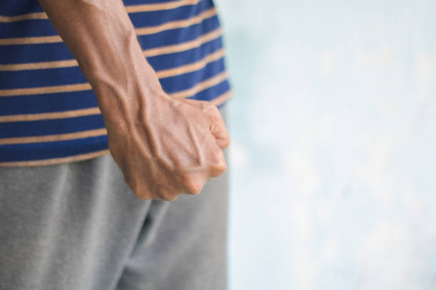 istock someone clenches their fists ready to hit. 2205473162