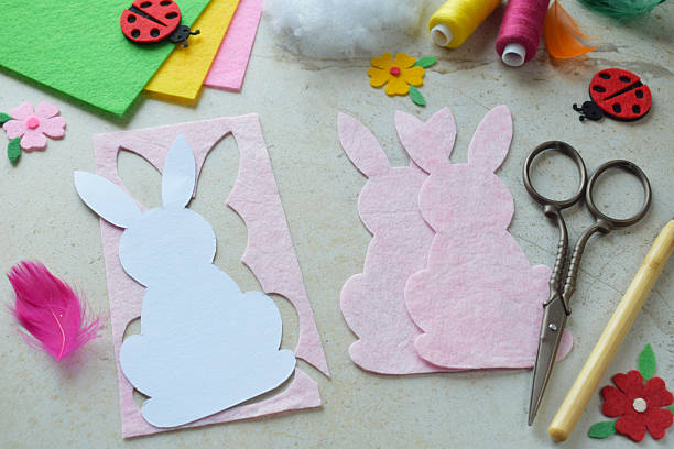 istock Handmade Easter Bunny Felt Craft Project with Colorful Threads, Scissors, Paper Template, and Decorative Hearts on Light Background. DIY Spring Decoration Idea for Kids and Hobby Enthusiasts 2205474085